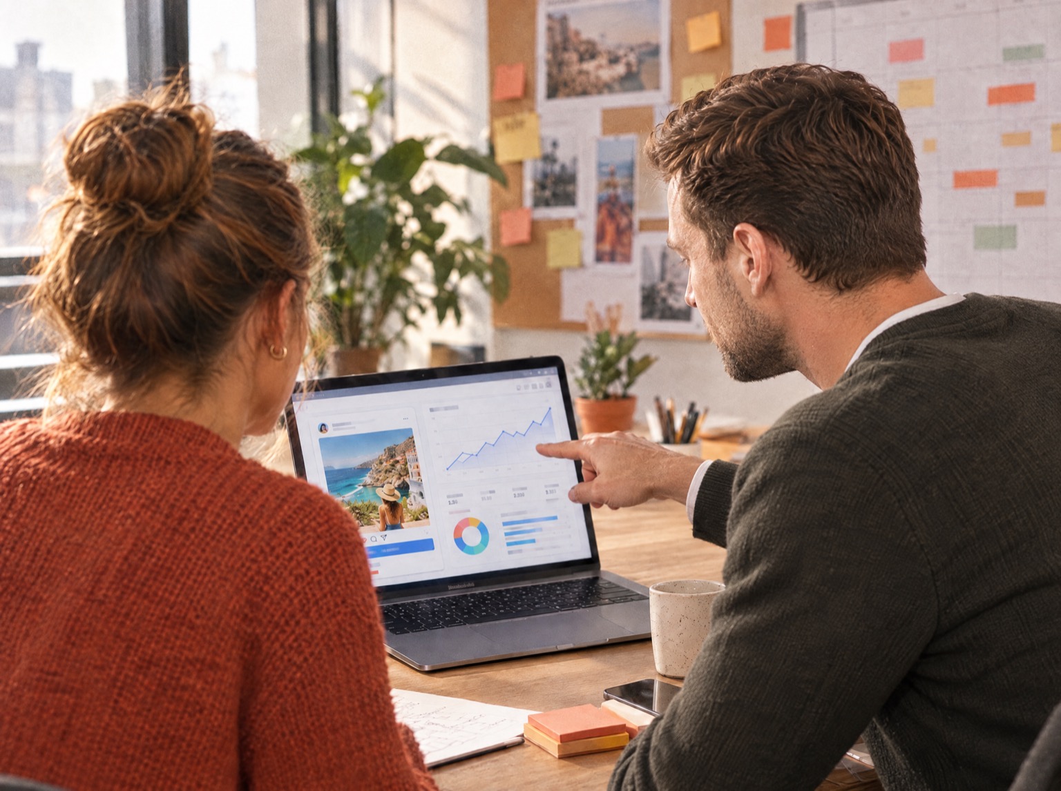 Zwei Personen besprechen vor einem MacBook eine Online-Marketing-Kampagne mit Diagrammen und einem Social-Media-Beitrag